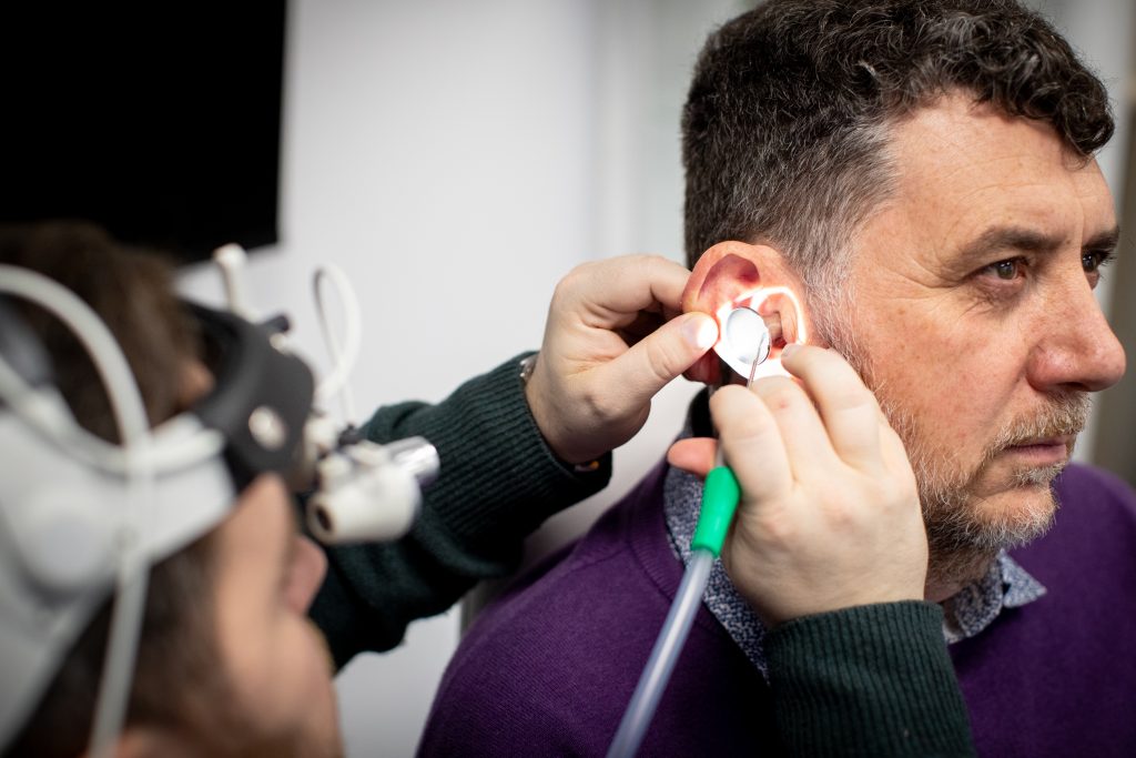 man has ear wax removed by microsuction in a London hearing clinic.